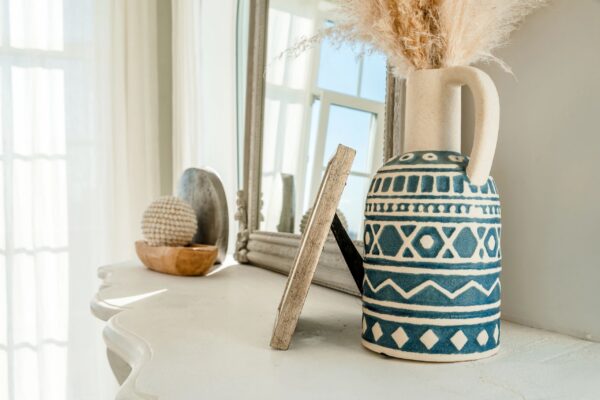 Beautiful cozy interior with vases and figurines, details of the white living room.