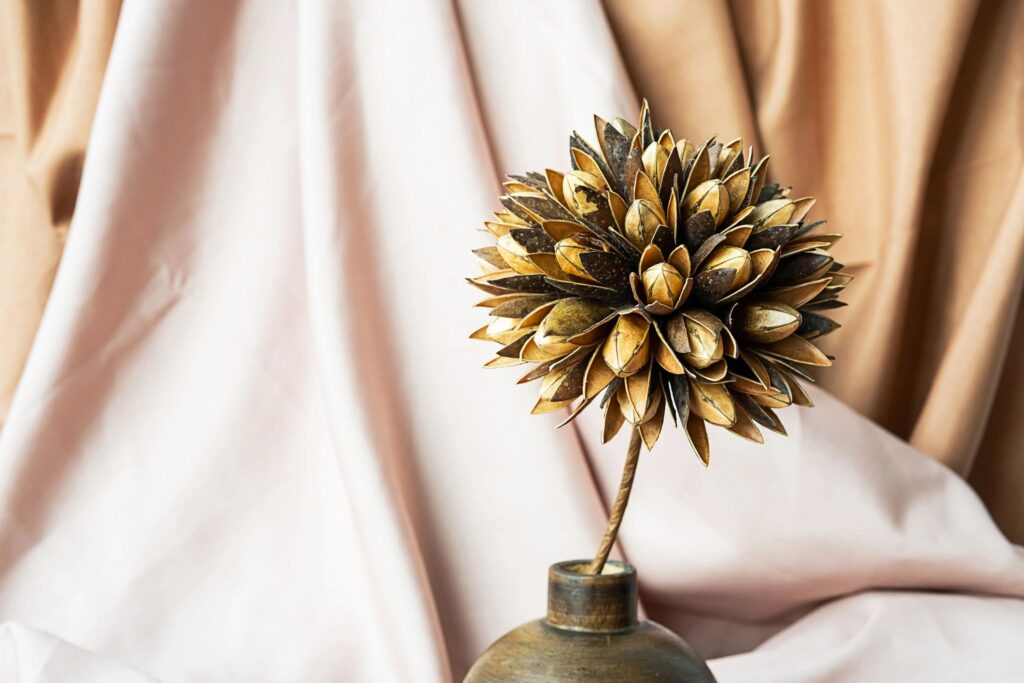 Dried flower in wooden vase against draper. Delicate modern still life.