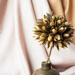 Dried flower in wooden vase against draper. Delicate modern still life.