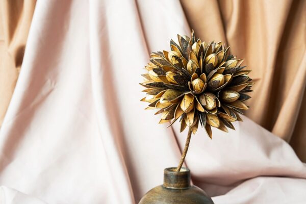 Dried flower in wooden vase against draper. Delicate modern still life.